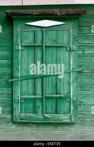 Old wooden window in a wall painte in green color. Astrakhan, Russia. Stock Photo