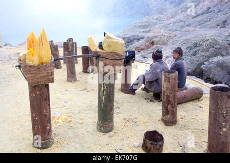 BANYUWANGI, EAST JAVA NOV 12: Indonesian sulphur miners taking a quick break before continuing to collect sulphur from Mt Ijen Stock Photo