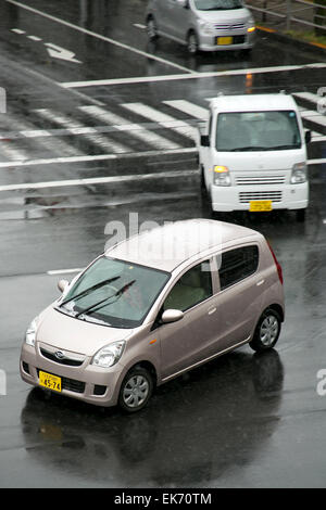 Tokyo, Japan. 8th April, 2015. Cars cross the street under unexpected snow on April 8, 2015 in Hachioji, Tokyo, Japan. This morning the weather forecast reported snow in different areas throughout the country. This is a really unusual phenomenon in Spring, especially during the cherry blossoms season, broadly known for the nice and warm weather. Credit:  Rodrigo Reyes Marin/AFLO/Alamy Live News Stock Photo
