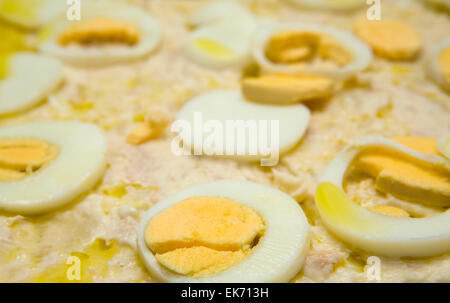 A plate of potato salad covered with sliced hard-boiled eggs and mayonnaise Stock Photo