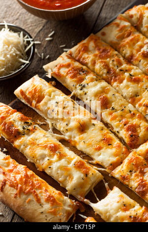Homemade Cheesy Breadsticks with Marinara Sauce for Dipping Stock Photo