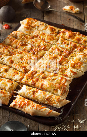 Homemade Cheesy Breadsticks with Marinara Sauce for Dipping Stock Photo