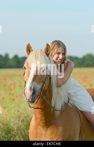 Young woman wearing white dress Haflinger horse Germany