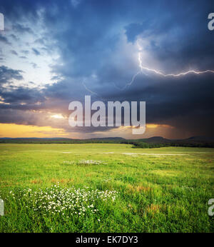 Meadow in mountain. Rain cloud and lightning. Nature composition. Stock Photo