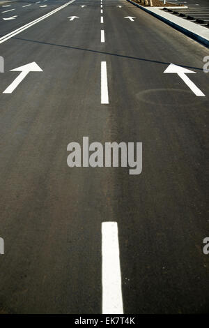 Road markings in the form of arrows on the asphalt road in the city Stock Photo