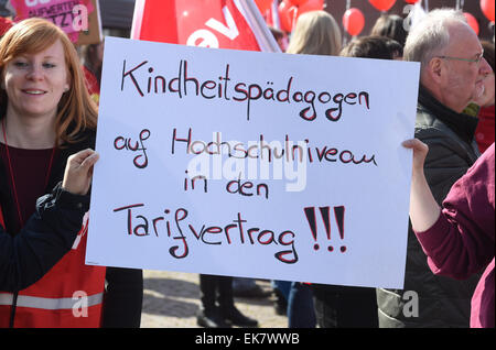 Karlsruhe, Germany. 08th Apr, 2015. Pre-school teachers gather during a warning strike in Karlsruhe, Germany, 08 April 2015, holding a sign that reads 'Kindheitspaedagogen auf Hochschulnivea in den Tarifvertrag!!!' (Include childhood educators with university degrees in the labour contract!!!). German trade unions Verdi and GEW demand adjustments to wage brackets, which would ultimately increase the salaries of childcare assistants, pre-school teachers and social workers currently employed by local social service facilities. Photo: Uli Deck/dpa/Alamy Live News Stock Photo