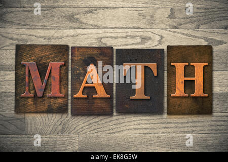 The word "MATH" theme written in vintage, ink stained, wooden letterpress type on a wood grained background. Stock Photo