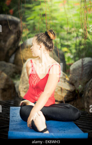 Young woman is practicing yoga outdoor Stock Photo