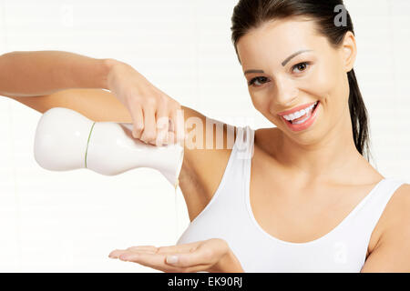 Young woman pouring olive oil from glass bottle Stock Photo