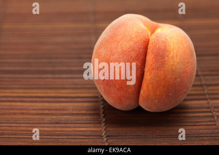 Peach on a bamboo mat Stock Photo