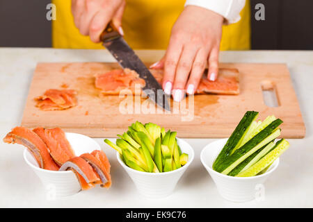 chef cuts the fillet of red fish on a wooden board Stock Photo