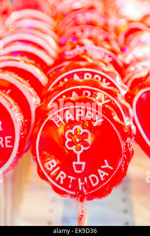 An image of a row of Happy Birthday lollipops on sticks in bright red Stock Photo