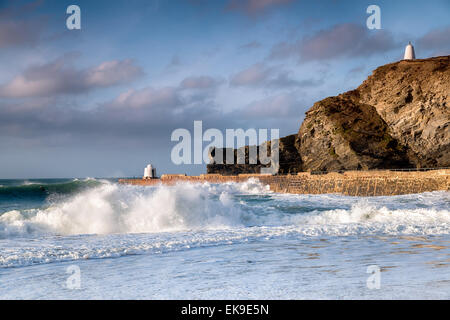 Waves and surf at Portreath harbour on the coast of Cornwall, the structure on the pier is known as the Monkey Hut and the one o Stock Photo