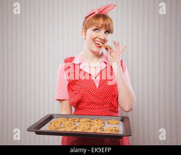 Retro housewife sneaking cookies Stock Photo