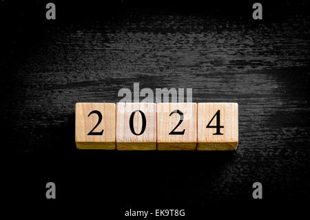 Year 2024. Wooden small cubes with numbers isolated on black background with copy space available. New Year Concept image. Stock Photo