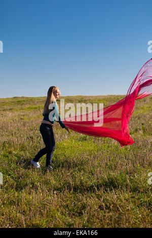 young beautiful woman jumping with tissue into the field against Stock Photo