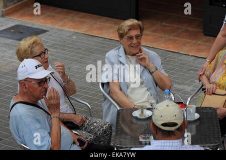 Senior people sitting around the table outside in Barcelona, Catalunya, Spain, August 2014 Stock Photo