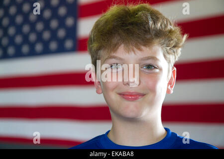 Ten year old american boy standing in front of an american flag in Charleston, South Carolina, USA. MR Stock Photo