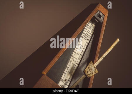 Color shot of a vintage metronome, on a black background. Stock Photo