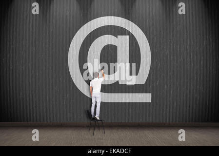 businessman standing on chair and drawing email symbol Stock Photo