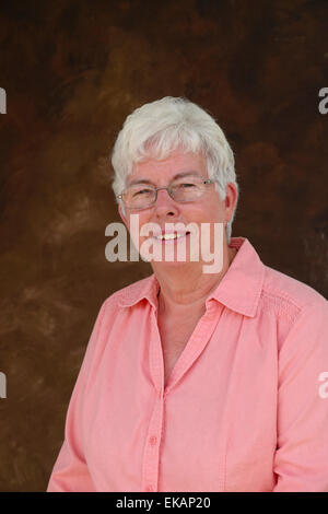 Elderly, white-haired woman smiles at the photographer. Stock Photo