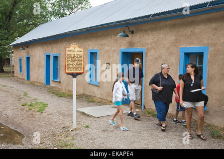 Visitors exit the Montano Store, one of many historic buildings at the Lincoln State Monument in Lincoln, New Mexico Stock Photo