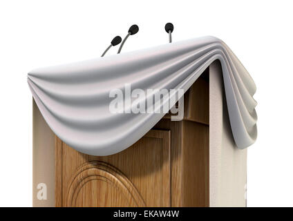 A wooden speech podium with three small microphones attached and decorated with generic white draping on an isolated white studi Stock Photo