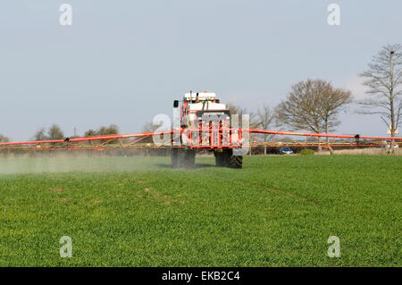 tractor spraying crops crop spraying tractors field fields farm farming farms agriculture farmer farmers pesticide pesticides in Stock Photo