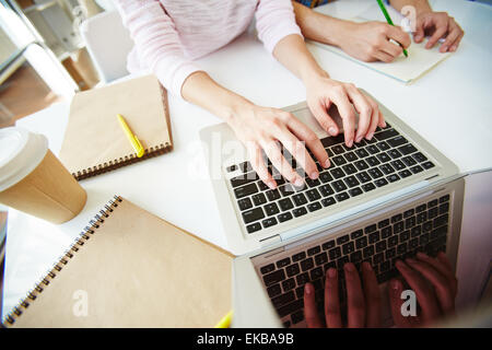 Female student typing on laptop at workplace Stock Photo
