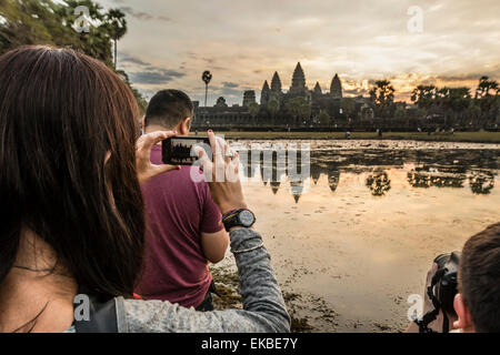 Tourists photographing the sunrise over the west entrance to Angkor Wat, Angkor, UNESCO, Siem Reap, Cambodia, Indochina, Asia Stock Photo