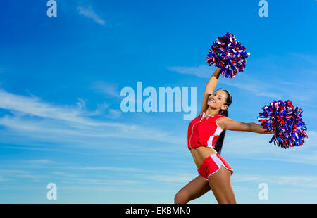 Young cheerleader in red costume with pampon Stock Photo