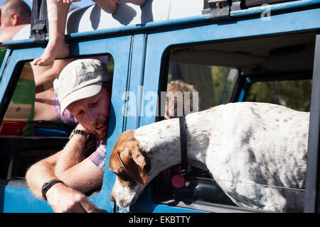 Mature man and dog leaning out of off road vehicle windows, Lake Okareka, New Zealand Stock Photo