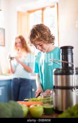 Teenage boy cutting vegetables in kitchen Stock Photo
