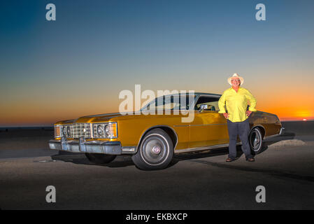 Portrait of senior man standing beside yellow car