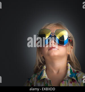 Portrait of young boy wearing 3 pairs of sunglasses Stock Photo