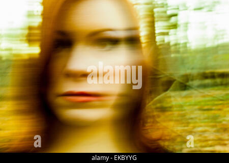 Portrait of mid adult woman, outdoors, blurred motion Stock Photo