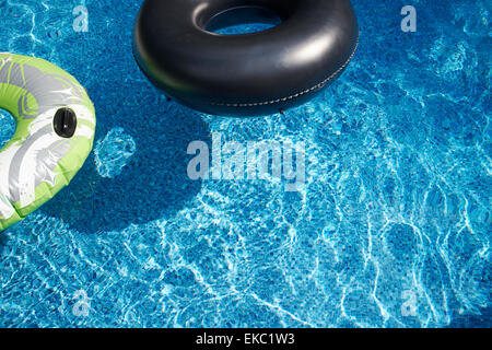 Two rubber rings in sunlit swimming pool Stock Photo