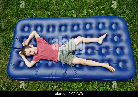 Overhead view of boy lying on inflatable mattress