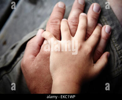 Close up of father and sons hands touching Stock Photo
