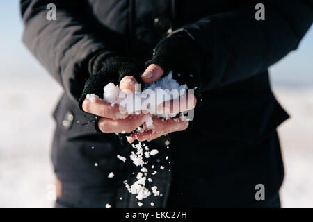 Woman holding snow in hands Stock Photo