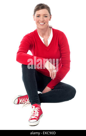 Pretty woman in casuals sitting on the floor Stock Photo
