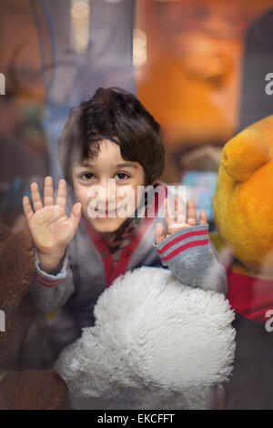 Smiling boy looking through window Stock Photo