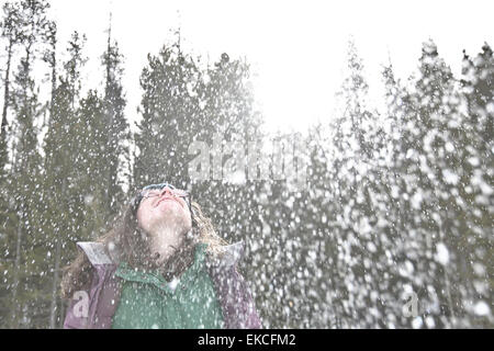 Woman in the snow throwing her head back and laughing Stock Photo
