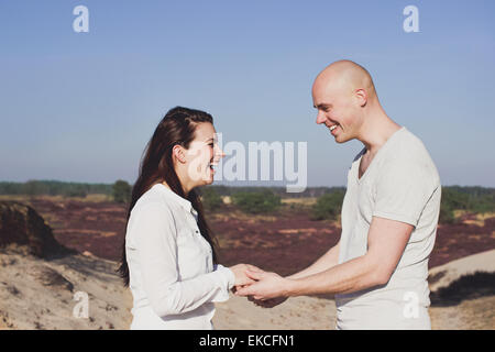 Portrait of a couple holding hands, laughing Stock Photo