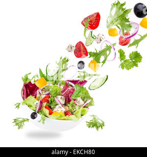 Fresh salad with flying vegetables ingredients isolated on a white background. Stock Photo
