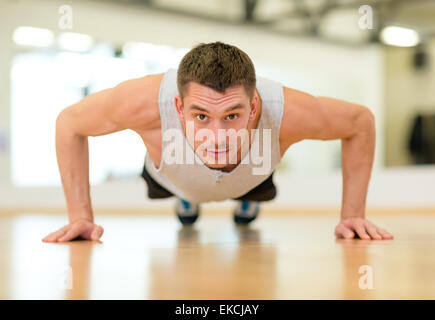 concentrated man doing push-ups in the gym Stock Photo
