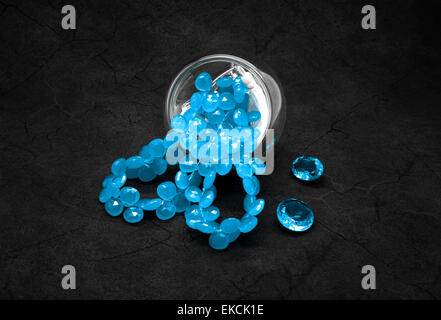 Blue beads and topazes on the cracked dark gray background. Stock Photo