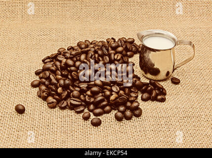 Retro photo of coffee beans on burlap background. Stock Photo