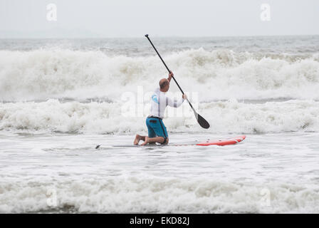 Man paddling out into the surf on a paddle board Upper Cheung Sha Beach Lantau Island Hong Kong China Stock Photo