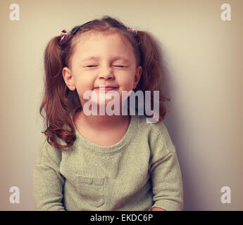 Happy smiling emotion girl screwing up her eyes and waiting surprise. Vintage closeup portrait Stock Photo